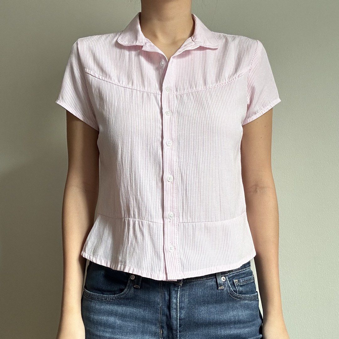 THREEK Pink Pinstripe Button Down Shirt (Category: Shirts) located in Manila. Submitted by lovedby.k (Listing ID 1468332130, Image 1). Description: 𝗜𝘁𝗲𝗺 𝗗𝗲𝘁𝗮𝗶𝗹𝘀: Condition: 9/10 in mint condition! Size: M on tag, best fits S - has ties at the back 𝗠𝗼𝗱𝗲𝗹’𝘀 𝗠𝗲𝗮𝘀𝘂𝗿𝗲𝗺𝗲𝗻𝘁𝘀: Bust 34-36, Size S-M, Height 5’5 🔖 All items are 𝗽𝗿𝗲𝗼𝘄𝗻𝗲𝗱!.