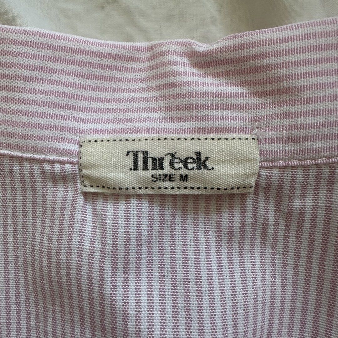 THREEK Pink Pinstripe Button Down Shirt (Category: Shirts) located in Manila. Submitted by lovedby.k (Listing ID 1468332130, Image 3). Description: 𝗜𝘁𝗲𝗺 𝗗𝗲𝘁𝗮𝗶𝗹𝘀: Condition: 9/10 in mint condition! Size: M on tag, best fits S - has ties at the back 𝗠𝗼𝗱𝗲𝗹’𝘀 𝗠𝗲𝗮𝘀𝘂𝗿𝗲𝗺𝗲𝗻𝘁𝘀: Bust 34-36, Size S-M, Height 5’5 🔖 All items are 𝗽𝗿𝗲𝗼𝘄𝗻𝗲𝗱!.