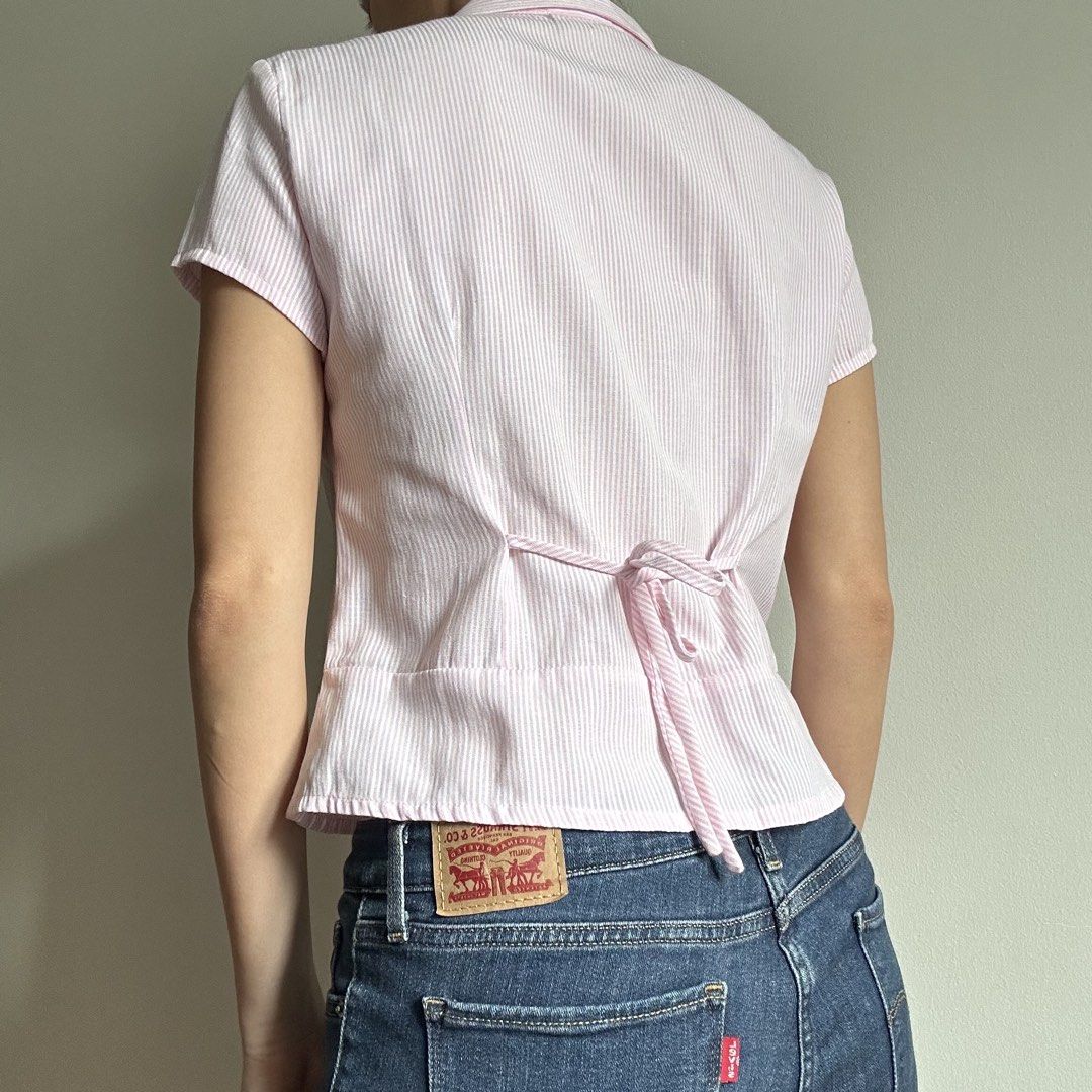THREEK Pink Pinstripe Button Down Shirt (Category: Shirts) located in Manila. Submitted by lovedby.k (Listing ID 1468332130, Image 2). Description: 𝗜𝘁𝗲𝗺 𝗗𝗲𝘁𝗮𝗶𝗹𝘀: Condition: 9/10 in mint condition! Size: M on tag, best fits S - has ties at the back 𝗠𝗼𝗱𝗲𝗹’𝘀 𝗠𝗲𝗮𝘀𝘂𝗿𝗲𝗺𝗲𝗻𝘁𝘀: Bust 34-36, Size S-M, Height 5’5 🔖 All items are 𝗽𝗿𝗲𝗼𝘄𝗻𝗲𝗱!.