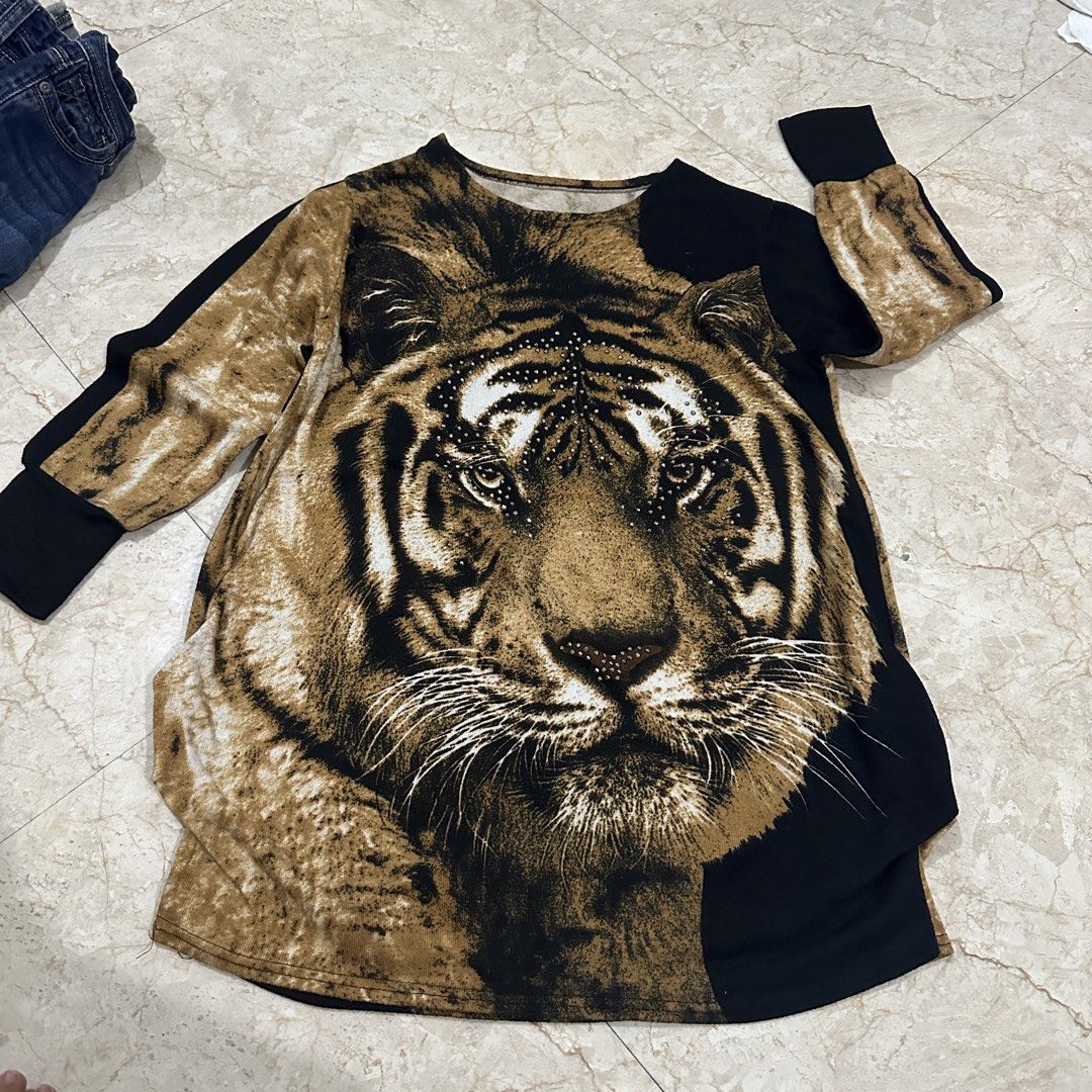 Tiger Print Rhinestone Long Sleeve Sweater (Category: Longsleeves) located in Kawit. Submitted by wevibevintage (Listing ID 1468462737, Image 1). Description: - Design: Bold tiger face graphic with rhinestone accents on stripes and nose - Colors: Black and brown colorway - Fit & Style: Relaxed fit, long sleeves, and round neckline - Material: Soft and comfortable knit fabric - Details: Ribbed black cuffs - Condition: Great statement piece for cas