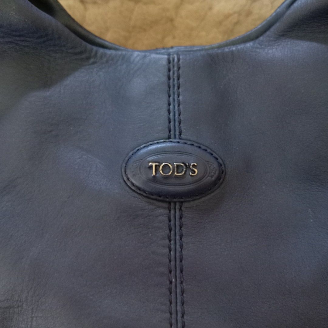 TOD'S Blue Leather Shoulder Bag (Category: Shoulder Bags) located in Baguio. Submitted by sheren_signatures (Listing ID 1468286437, Image 3). Description: - Brand: TOD'S - Color: Dark Blue - Material: Genuine Leather with silver-tone hardware - Straps: Double top handles and a detachable shoulder strap - Closure: Magnetic snap top closure - Interior: TOD'S monogram fabric lining with a zippered pocket - Authenticity: Includes 'Made in Italy', 'Ge