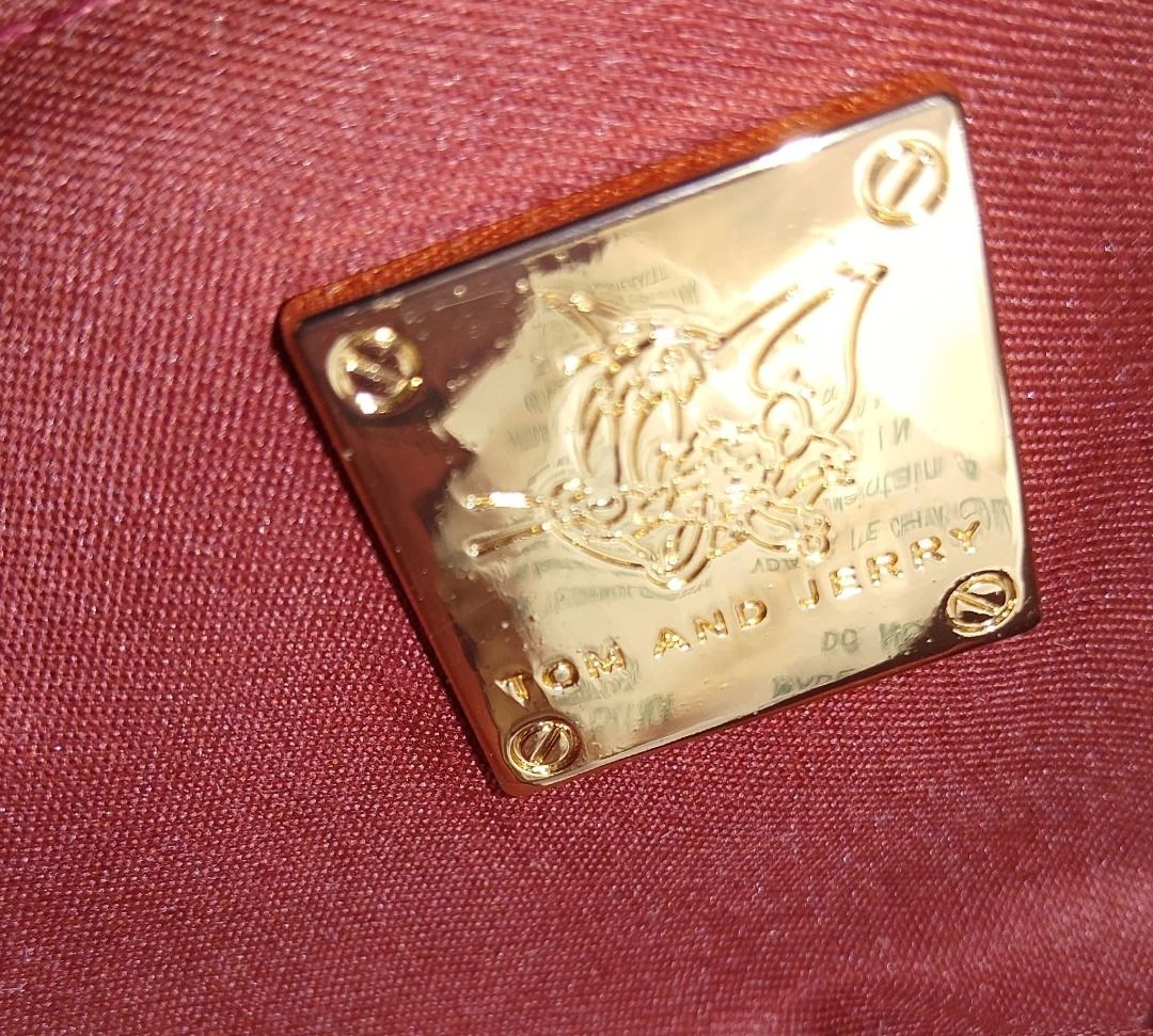 Tom And Jerry Pink Adjustable bag- original (Category: Luxury Bags & Wallets) located in Manila. Submitted by hisandherscloset2025 (Listing ID 1468463015, Image 2). Description: - Official Tom and Jerry gold metal plaque - Shiny finish with engraved cartoon character art - Detailed with four corner screw accents - Attached to a dark red fabric lining - Clean surface with clear lettering at the bottom - Fun and unique accessory for cartoon fans - 