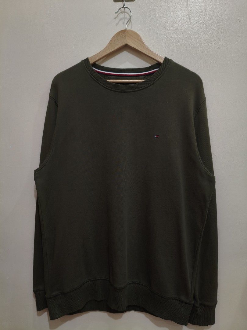 Tommy Hilfiger Olive Green Crewneck Pullover Sweatshirt (Category: Coats, Jackets and Outerwear) located in Mandaluyong City. Submitted by frivsthriftsph (Listing ID 1468453768, Image 1). Description: Tommy Hilfiger Olive Green Crewneck Pullover Sweatshirt Like new condition. Color rate is 9/10. Size L on tag. Actual dimes are 23W by 30L. No issue..