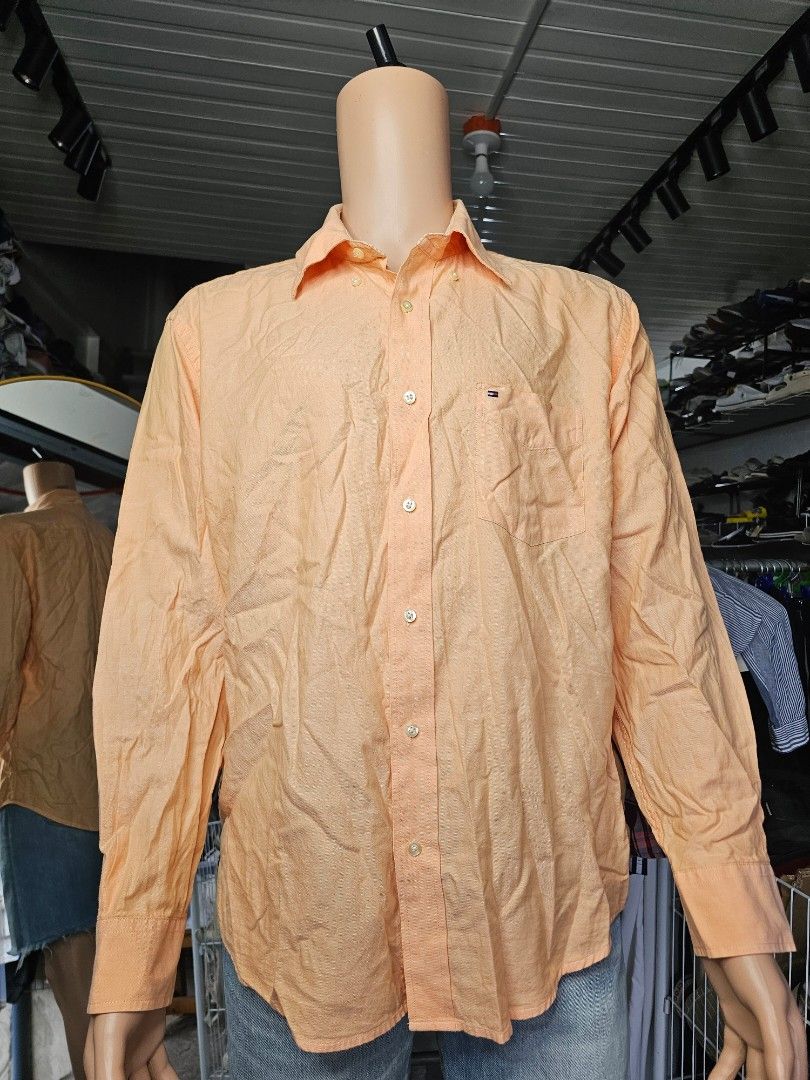 Tommy Hilfiger Shirt (Category: Formal Shirts) located in Baguio. Submitted by kayeonlineshop (Listing ID 1468299183, Image 2). Description: orange or peach-colored long-sleeve button-down dress shirt with a chest pocket and a small Tommy Hilfiger flag logo embroidery..