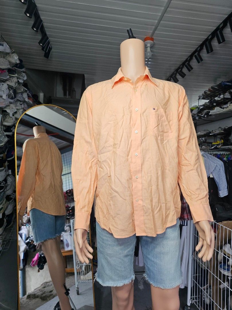 Tommy Hilfiger Shirt (Category: Formal Shirts) located in Baguio. Submitted by kayeonlineshop (Listing ID 1468299183, Image 1). Description: orange or peach-colored long-sleeve button-down dress shirt with a chest pocket and a small Tommy Hilfiger flag logo embroidery..