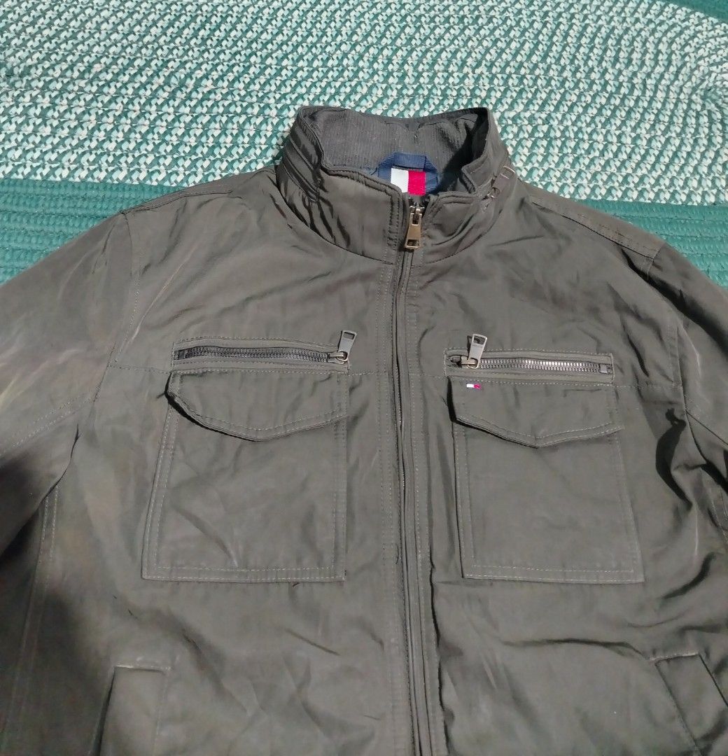 Tommy Hilfiger Water Resistant Wind Resistant Jacket Size L (Category: Coats, Jackets and Outerwear) located in Lucena. Submitted by thrifteditem (Listing ID 1468338355, Image 3). Description: - Brand: Tommy Hilfiger - Color: Dark Green - Size: Large - Features: Water resistant, wind resistant, full zip front - Pockets: Multiple functional pockets on chest and lower body - Details: Ribbed collar, cuffs, and hem for a snug fit - Perfect for: Casua