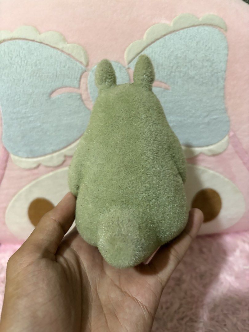 Totoro (Category: Figurines & Statues) located in Naic. Submitted by rmcollectibles (Listing ID 1468438079, Image 2). Description: - Official Studio Ghibli Green Totoro figurine - Unique, soft-to-the-touch fuzzy flocked texture - Classic design featuring white tummy markings and whiskers - Stands upright easily on any flat surface - Features a small hole underneath the base (likely from a previous display stand) - Perfect decor piece for desks, s