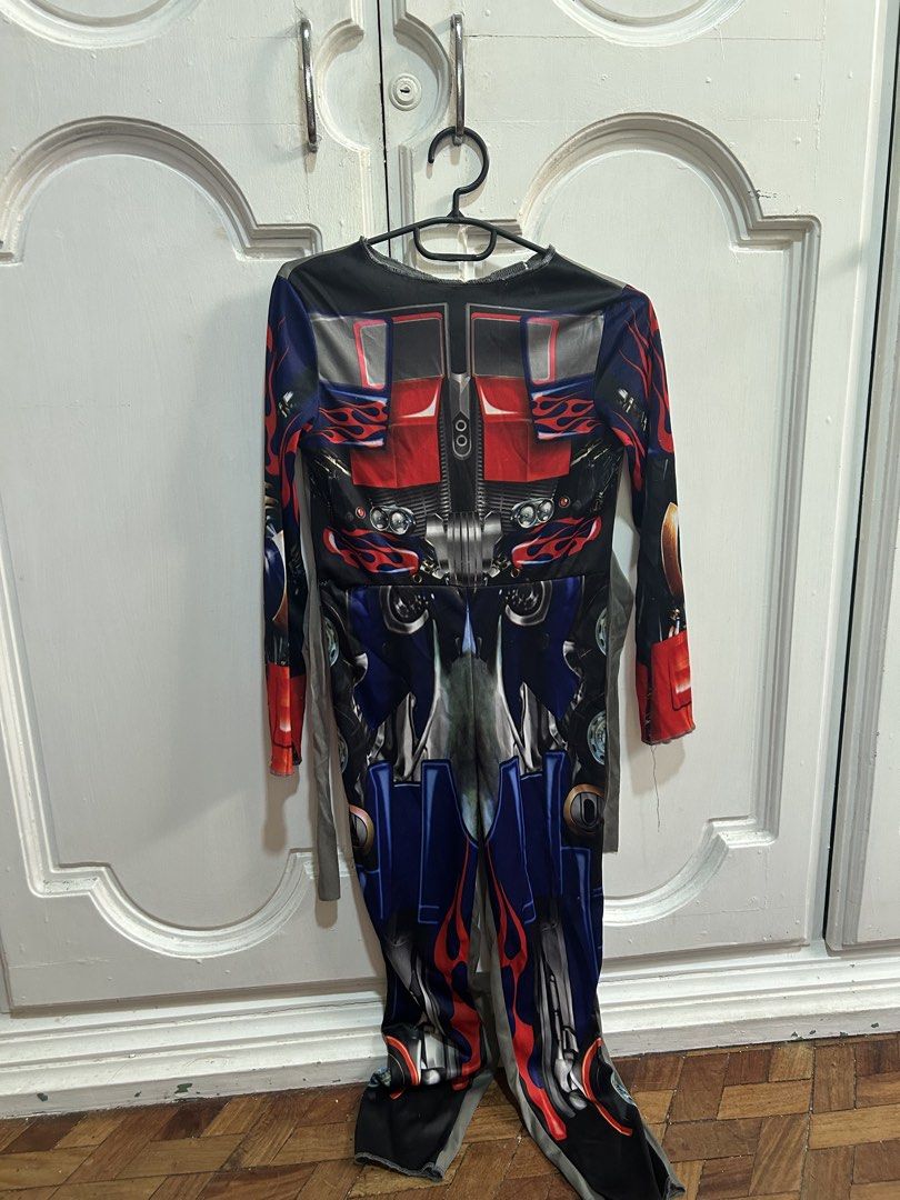 Transformers Optimus Prime Costume Size M 7-8 (Category: Babies & Kids Fashion) located in Meycauayan. Submitted by ms.einz (Listing ID 1468354607, Image 1). Description: - Official Hasbro and DreamWorks licensed Transformers Optimus Prime costume - Size: M (fits kids ages 7-8 years) - Design: Vibrant red, blue, and black full-body print with long sleeves and attached grey fabric ties - Measurements: Approx. 15 inches across chest, 42 inches tota