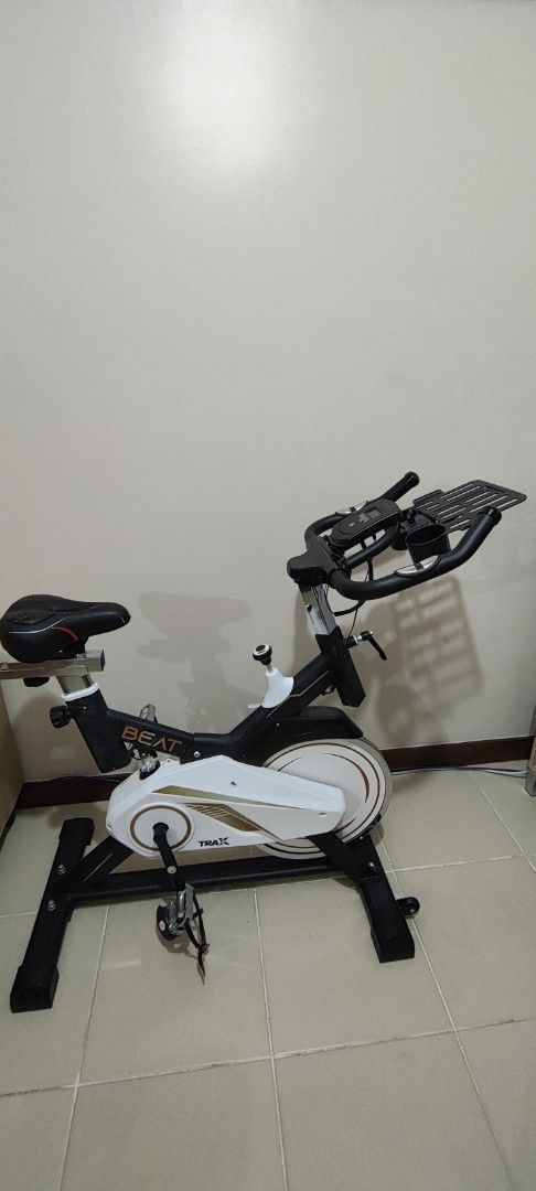 TRAX Cadence Beat Indoor Exercise Bike (Category: Cardio & Fitness Machines) located in Caloocan City. Submitted by pcadiz (Listing ID 1468499833, Image 1). Description: - Brand/Model: TRAX Cadence Beat - Color: Black and white frame with stylish gold accents - Digital Monitor: Tracks scan, time, speed, distance, calories, and odometer (current reading: 111.6 km) - Conveniences: Built-in tablet holder and water bottle holder on handlebars - Condi