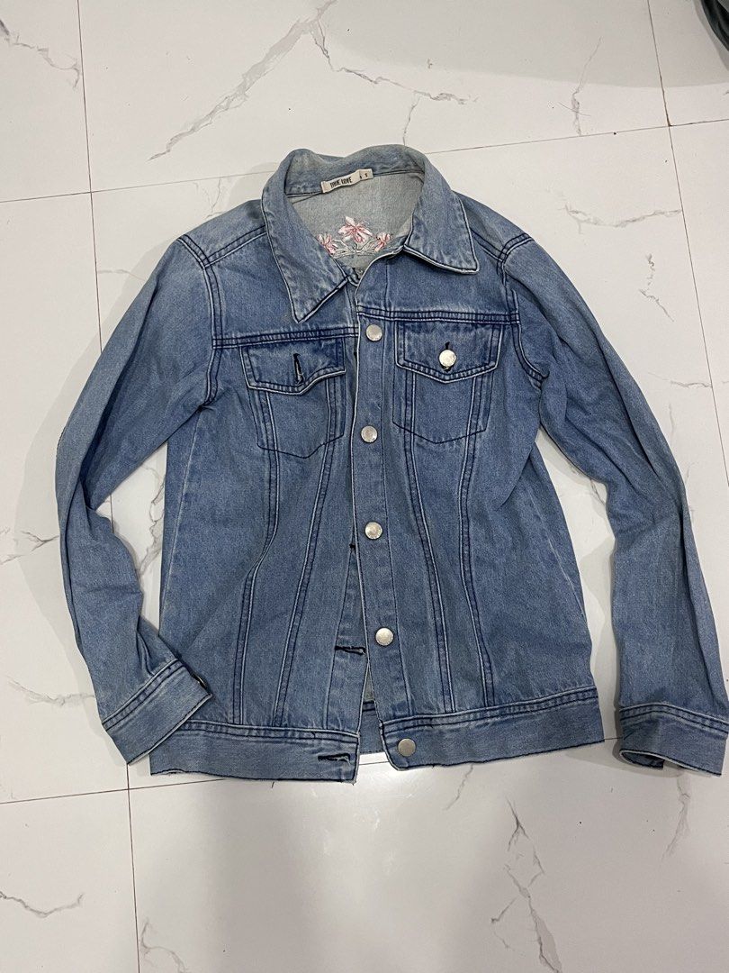 True Love Denim Jacket Size S Blue (Category: Coats, Jackets and Outerwear) located in Caloocan City. Submitted by xyzamym (Listing ID 1468386710, Image 1). Description: - Brand: True Love - Size: S - Color/Wash: Light wash denim - Material: Medium-weight cotton denim with a structured fit - Features: Classic button-up front with metal hardware, dual chest pockets, and side welt pockets - Special Detail: Small embroidered flower on the inside bac