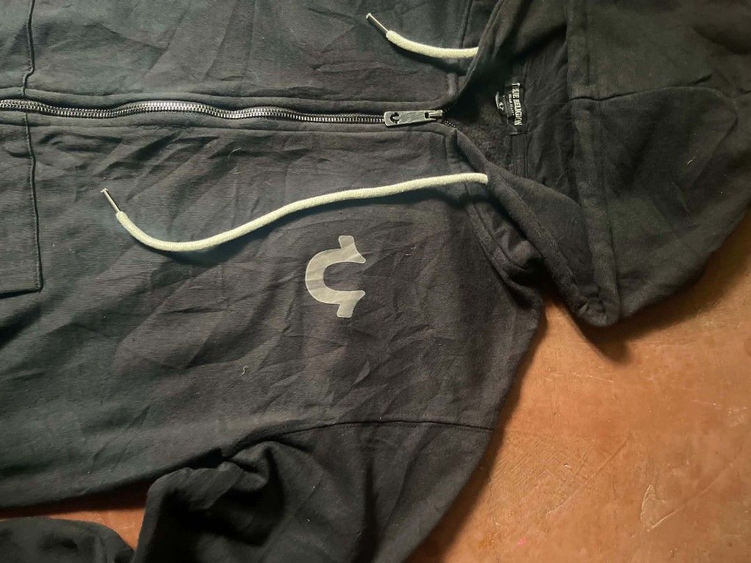 True Religion Core Zip Hoodie Black XL (Category: Hoodies) located in Gumaca. Submitted by makuliti (Listing ID 1468307635, Image 2). Description: - Brand: True Religion - Style: Zip-up hoodie - Color: Black - Size: XL - Material: Thick cotton blend - Details: Front pockets, drawstring hood, signature horseshoe logo on chest, full metal zipper with branded pull tab - Condition: Great, clean condition overall - Perfect daily wear staple piece.