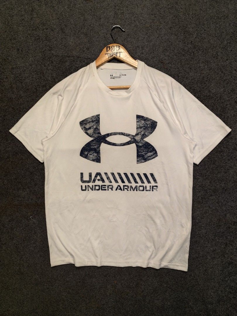 Under Armour Graphic T-Shirt (Category: Activewear) located in Cordova. Submitted by bsb.streetluxvintage.clothing (Listing ID 1468425055, Image 1). Description: - Brand: Under Armour - Size: XL (Loose fit) - Material: 100% polyester - Color: White - Design: Large graphic print with UA branding on the front, small logo near the back collar - Condition: Excellent - Origin: Made in Cambodia.