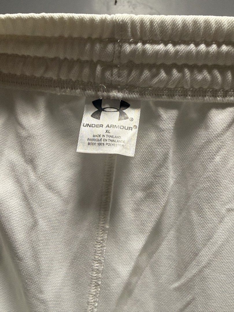 Under Armour White Track Pants with Drawstring (Category: Joggers) located in Manila. Submitted by swiftgem.eeb06e (Listing ID 1468390245, Image 3). Description: - Brand: Under Armour - Color: White with black logo and side piping - Fit: Elastic waistband with drawstring and cuffed ankles - Fabric: Soft, lightweight, and breathable - Best for: Gym workouts, running errands, or casual lounging - Condition: Excellent / Like new - Mode of Payment: G