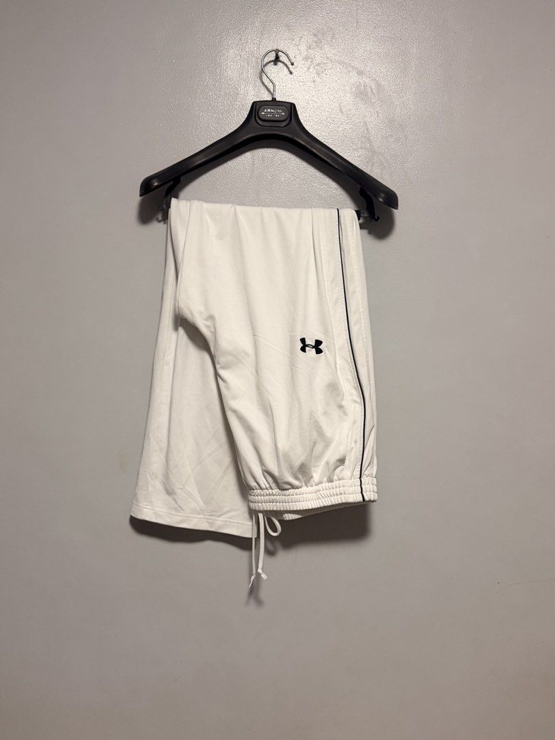 Under Armour White Track Pants with Drawstring (Category: Joggers) located in Manila. Submitted by swiftgem.eeb06e (Listing ID 1468390245, Image 1). Description: - Brand: Under Armour - Color: White with black logo and side piping - Fit: Elastic waistband with drawstring and cuffed ankles - Fabric: Soft, lightweight, and breathable - Best for: Gym workouts, running errands, or casual lounging - Condition: Excellent / Like new - Mode of Payment: G