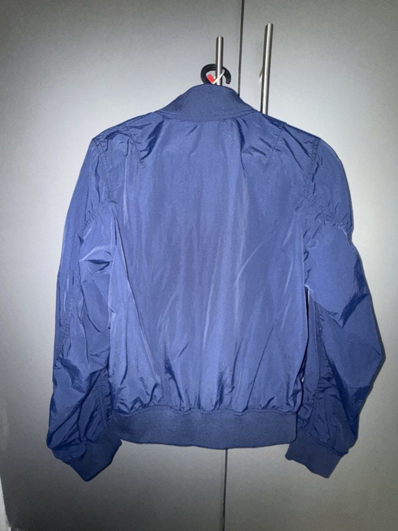 Uniqlo Navy Blue Bomber Jacket (Category: Coats, Jackets and Outerwear) located in Makati City. Submitted by joyfulliving22 (Listing ID 1468322509, Image 2). Description: - Brand: Uniqlo - Color: Navy blue - Material: 100% nylon with polyester/spandex ribbing - Features: Full zip front, ribbed collar/cuffs/hem, two front hand pockets - Condition: Clean inside and out - Style: Great lightweight layer for breezy weather.
