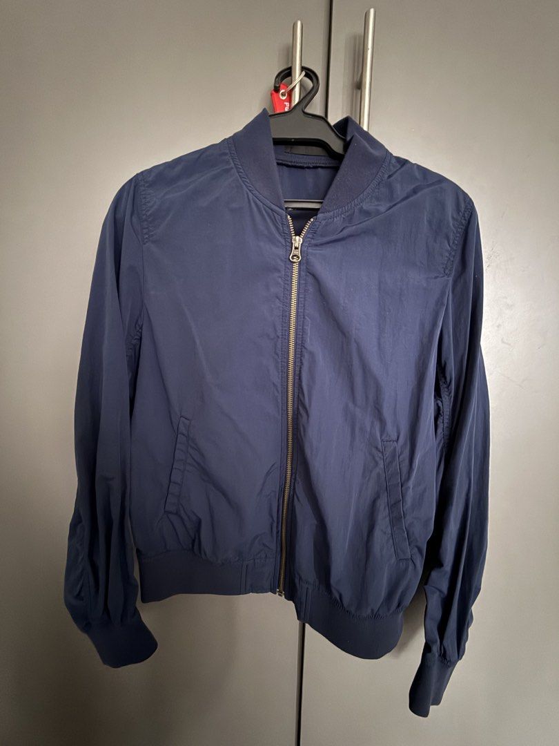 Uniqlo Navy Blue Bomber Jacket (Category: Coats, Jackets and Outerwear) located in Makati City. Submitted by joyfulliving22 (Listing ID 1468322509, Image 1). Description: - Brand: Uniqlo - Color: Navy blue - Material: 100% nylon with polyester/spandex ribbing - Features: Full zip front, ribbed collar/cuffs/hem, two front hand pockets - Condition: Clean inside and out - Style: Great lightweight layer for breezy weather.