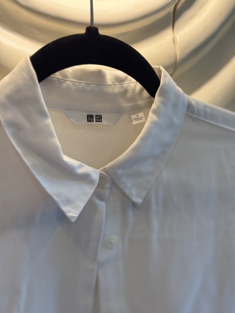 Uniqlo White Button Up Shirt Size S (Category: Shirts) located in Angeles City. Submitted by adeclutters__ (Listing ID 1468340419, Image 2). Description: - Brand: Uniqlo - Item: White button-up shirt - Size: Small - Design: Classic collared neckline with front button closure - Material: Lightweight and easy to style - Occasion: Perfect for work or casual outings - Condition: Clean and ready to wear 600 for 2.