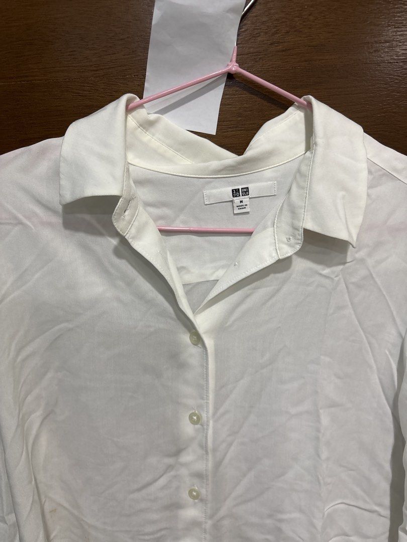 Uniqlo White Long Sleeve Button-Down Shirt Size M (Category: Longsleeves) located in Mandaluyong City. Submitted by clothescarousel (Listing ID 1468440921, Image 3). Description: Uniqlo white long sleeve button-down shirt in size M. Classic collar neckline and front button closure. Standard cuffs on sleeves. Clean solid white fabric with standard hemline. Note there are minor yellowish stains near the lower front button area as pictured..