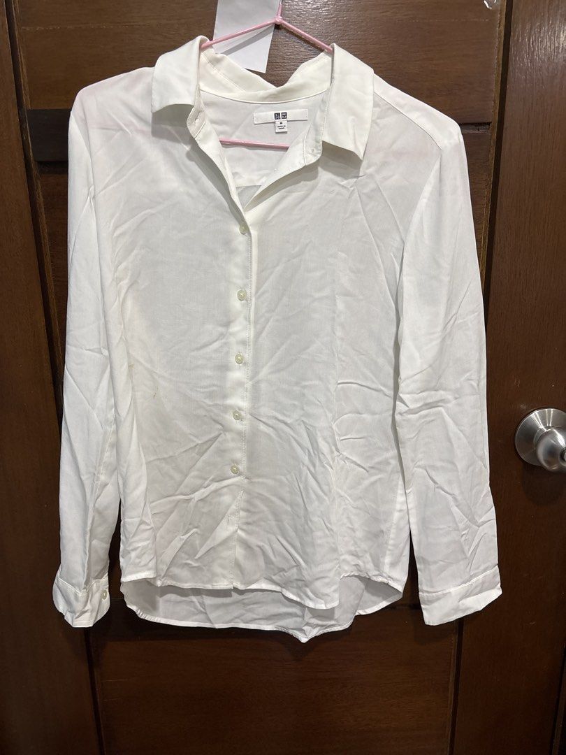 Uniqlo White Long Sleeve Button-Down Shirt Size M (Category: Longsleeves) located in Mandaluyong City. Submitted by clothescarousel (Listing ID 1468440921, Image 1). Description: Uniqlo white long sleeve button-down shirt in size M. Classic collar neckline and front button closure. Standard cuffs on sleeves. Clean solid white fabric with standard hemline. Note there are minor yellowish stains near the lower front button area as pictured..