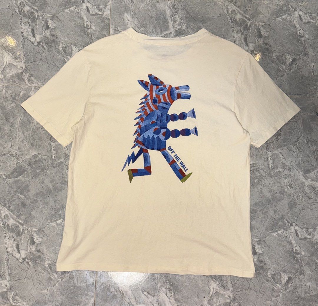 Vans Off The Wall Graphic Tee Relaxed Fit Medium (Category: Tshirts & Polo Shirts ) located in Manila. Submitted by tanlaxfinds (Listing ID 1468321325, Image 3). Description: - Brand: Vans - Color: Cream - Size: Medium (Relaxed fit) - Design: Small blue chest logo, bold colorful creature graphic on the back with 'OFF THE WALL' text - Details: Woven Vans tag on the left sleeve - Origin: Made in China - Condition: Clean, no noticeable flaws.