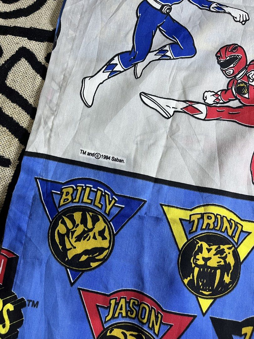 Vintage 1994 Mighty Morphin Power Rangers Bed Sheet (Category: Bedding & Towels) located in Silang. Submitted by yusthrift (Listing ID 1468367036, Image 2). Description: - Official 1994 Saban Mighty Morphin Power Rangers bed sheet - Bright blue and white pattern featuring Jason, Zack, Billy, Trini, and Kimberly - Includes iconic dino coins and logo text - Clean fabric with vibrant, well-preserved prints - A must-have classic retro bedroom piece f