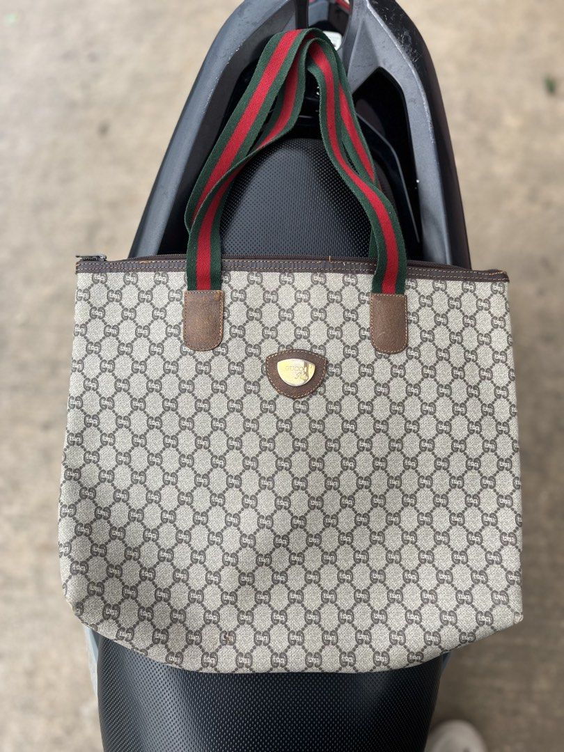Vintage Gucci Plus Monogram Tote Bag (Category: Tote Bags) located in Tacloban City. Submitted by luxbag_phhh (Listing ID 1468341422, Image 1). Description: Gucci Plus monogram canvas tote bag with the classic green and red web stripe handles. Brown leather trim and gold-tone hardware badge on the front. Zip top closure. Inside features fabric lining with an internal slip pocket and leather brand tag stamped Made in Italy. Authentic.
