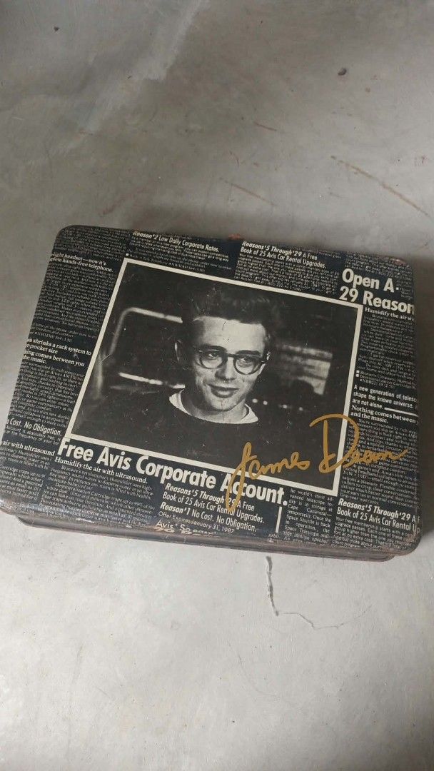 Vintage James Dean tin attachicase (Category: Luggage) located in Mandaluyong City. Submitted by LEATHERFACE (Listing ID 1468321225, Image 2). Description: - Unique vintage metal suitcase with newspaper print graphics - Features a striking central portrait and gold signature of James Dean - Equipped with a sturdy black plastic top handle and secure metal latches - Shows authentic rust and wear consistent with its age, adding to its vintage charm 