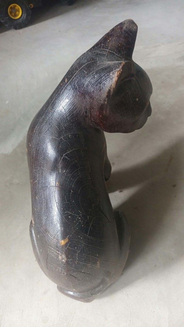 Vintage wooden cat display (Category: Figurines & Statues) located in Mandaluyong City. Submitted by LEATHERFACE (Listing ID 1468323903, Image 2). Description: - Handcrafted solid wooden cat sculpture - Sitting pose with a dark finish - Features unique natural wood grain and rustic aging cracks - Ideal rustic decor piece for shelves, desks, or mantels - Carefully packaged for safe delivery across the Philippines.
