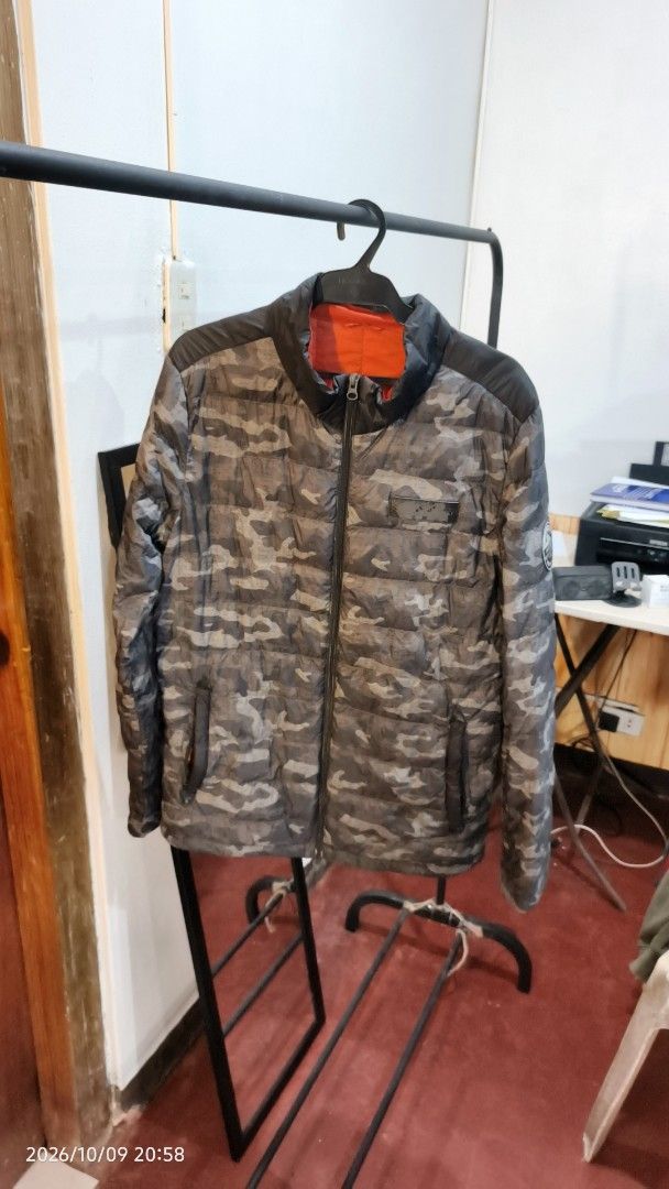 WARMAX Lonsdale Puffer Jacket Grey Camo (Category: Coats, Jackets and Outerwear) located in Baguio. Submitted by monde_46 (Listing ID 1468303104, Image 3). Description: - Brand: WARMAX - Design: Grey camo lower half with solid black upper back/shoulders - Accent: Lonsdale camping patch on the sleeve - Interior: Bright orange inner lining - Features: Front zip closure and two secure zippered pockets - Performance: Lightweight yet warm functional d