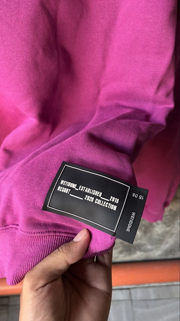 We11done Magenta Logo Sweatshirt (Category: Coats, Jackets and Outerwear) located in Cabuyao City. Submitted by bulandos (Listing ID 1468377390, Image 3). Description: - Brand: We11done (Resort 2020 Collection) - Color: Bright Magenta - Size: Medium (Boxy, oversized fit) - Material: Heavyweight cotton & polyurethane blend (Made in Korea) - Details: Large metallic front logo, small back print, branding on right sleeve, and distressed hem.