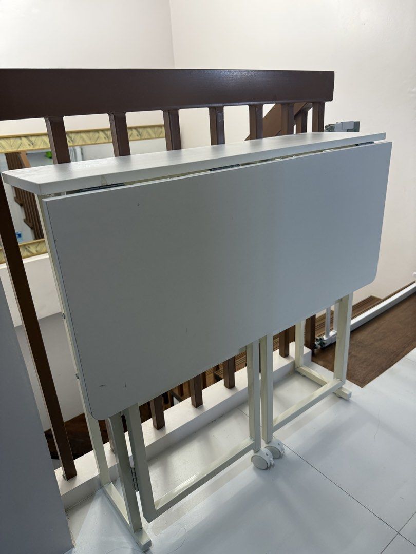 White 2-Layer Folding Computer Study Table with Wheels (Category: Tables & Sets) located in Guiguinto. Submitted by mustgobymarion (Listing ID 1468335209, Image 1). Description: - Color: White - Dimensions (Open): 80 x 58 x 75 cm - Dimensions (Folded): 80 x 24.5 x 75 cm - Features: Built-in storage shelf and smooth caster wheels for easy mobility - Design: Sturdy metal frame, folds flat for compact storage - Perfect for: Small bedrooms, study roo