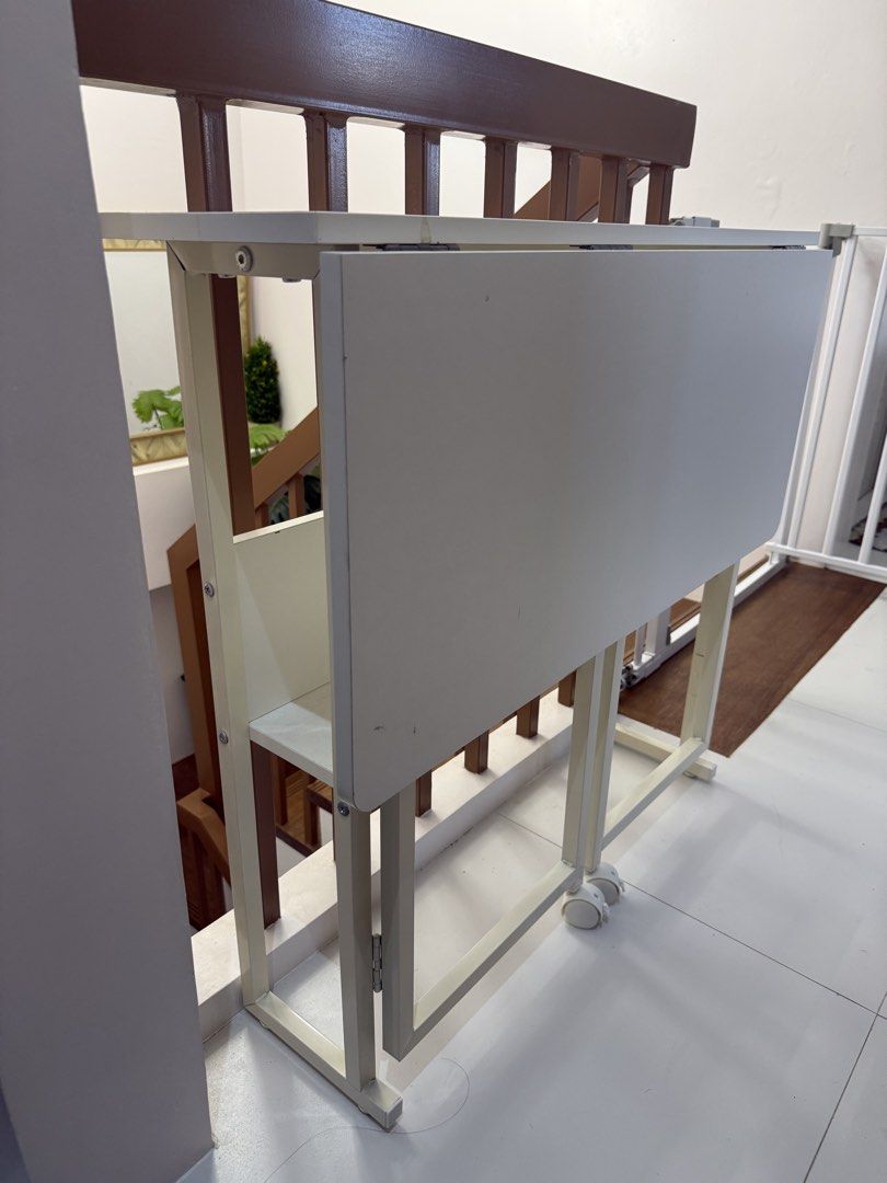 White 2-Layer Folding Computer Study Table with Wheels (Category: Tables & Sets) located in Guiguinto. Submitted by mustgobymarion (Listing ID 1468335209, Image 2). Description: - Color: White - Dimensions (Open): 80 x 58 x 75 cm - Dimensions (Folded): 80 x 24.5 x 75 cm - Features: Built-in storage shelf and smooth caster wheels for easy mobility - Design: Sturdy metal frame, folds flat for compact storage - Perfect for: Small bedrooms, study roo