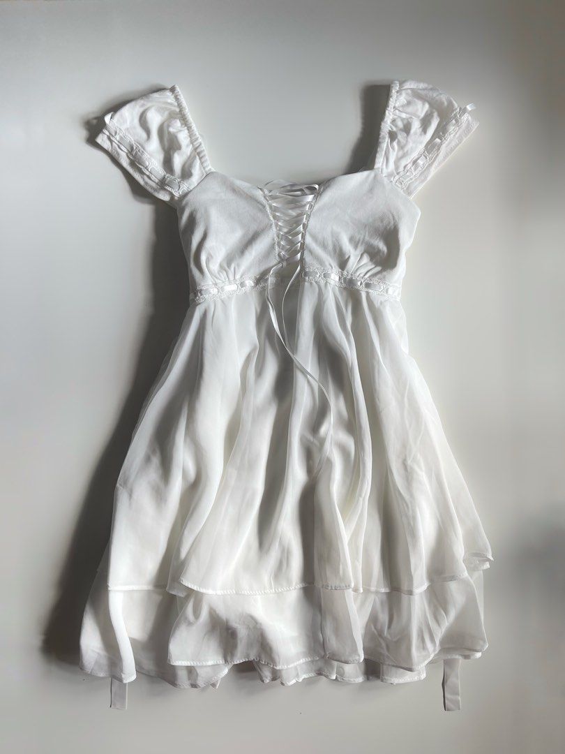 White Corset Mini Dress with Ribbons and Ruffles (Category: Dresses) located in Cavite. Submitted by devilourea (Listing ID 1468302392, Image 1). Description: - Color: White - Style: Fairycore & coquette aesthetic - Features: Short puffy sleeves with ribbon ties at the shoulders - Details: Front lace-up corset style with ribbon trim under the bust - Skirt: Flowy double-layered chiffon - Closure: Convenient side zipper - Material: Super soft and c