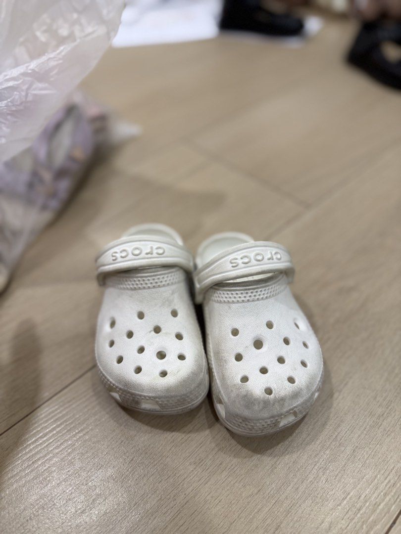 White Crocs Kids Clogs Size C7 (Category: Babies & Kids Fashion) located in Cavite. Submitted by bronurams2000 (Listing ID 1468456643, Image 2). Description: - Item: White Crocs Clogs for Kids - Size: C7 (molded into the sole) - Features: Classic ventilation holes, movable heel strap with embossed branding, and iconic comfort footbed - Condition: Soles show wear and dirt from outdoor use - Perfect for: Daily playground trips and easy slip-on wear