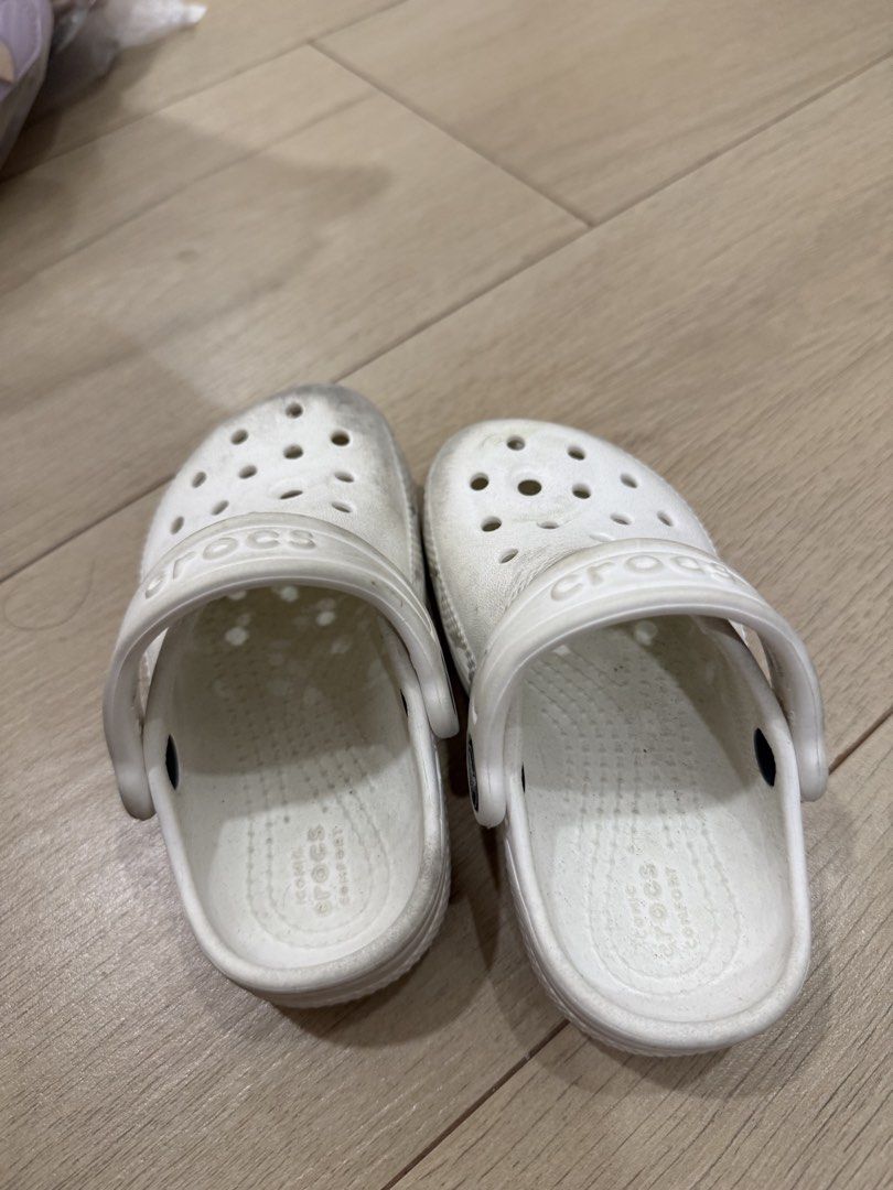 White Crocs Kids Clogs Size C7 (Category: Babies & Kids Fashion) located in Cavite. Submitted by bronurams2000 (Listing ID 1468456643, Image 1). Description: - Item: White Crocs Clogs for Kids - Size: C7 (molded into the sole) - Features: Classic ventilation holes, movable heel strap with embossed branding, and iconic comfort footbed - Condition: Soles show wear and dirt from outdoor use - Perfect for: Daily playground trips and easy slip-on wear