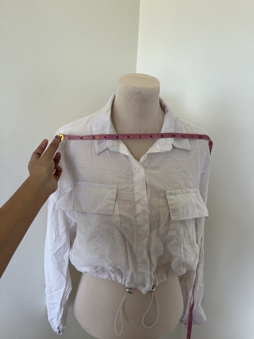 White Long Sleeve Button Down Crop Blouse (Category: Longsleeves) located in Mandaluyong City. Submitted by bravedeer.020ad7 (Listing ID 1468363139, Image 2). Description: - Color: White - Style: Button-down blouse with classic collar - Features: Long sleeves, dual chest pockets, and adjustable drawstring hem with silver hardware - Fabric: Lightweight and comfortable - Condition: Brand new / Excellent (Ready to ship!) .