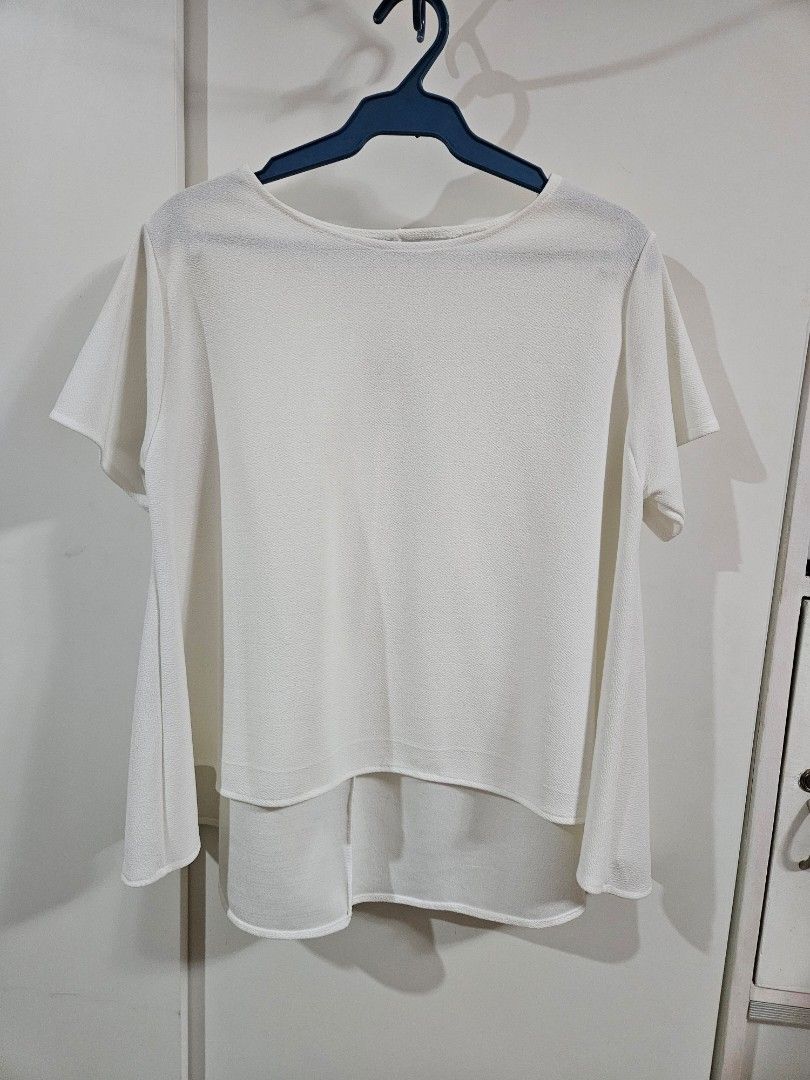 White short sleeve flowy blouse top (Category: Blouses) located in Caloocan City. Submitted by rm.diaz (Listing ID 1468290074, Image 1). Description: - Color: Solid white - Style: Short-sleeve blouse with scoop neckline - Fit: Relaxed fit with a nice, flattering drape - Fabric: Textured material - Versatility: Easy to pair with jeans, skirts, or work pants - Condition: Clean, smoke-free home.