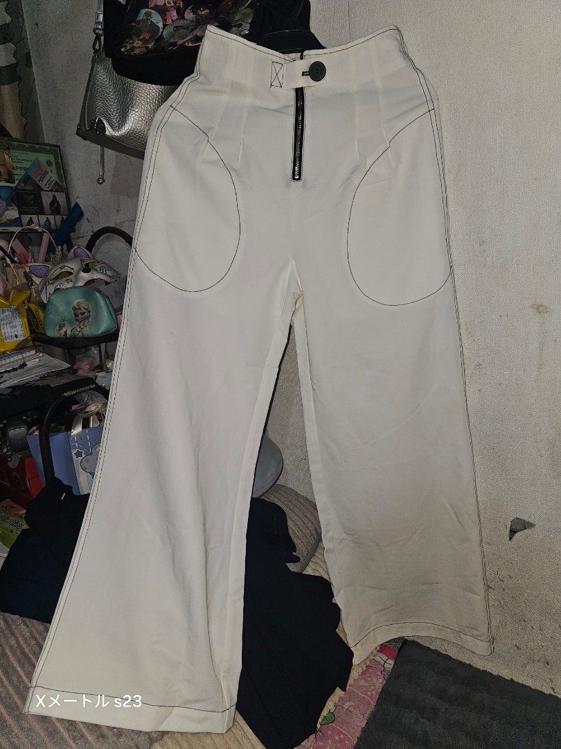White wide leg trousers pants (Category: Jeans) located in Manila. Submitted by billydelar93312 (Listing ID 1468359372, Image 1). Description: size 26-27 150 each - Color: White - Style: Wide leg, relaxed fit - Waist: High waist with button and zipper fly - Details: Chic contrast stitching around pockets - Versatility: Ideal for casual and smart-casual outfits.
