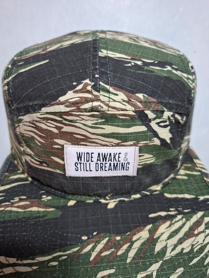 Wide Awake Still Dreaming Camo 5-Panel Hat (Category: Caps & Hats) located in Taguig. Submitted by AlfonsoJaimepreloved (Listing ID 1468461719, Image 2). Description: Wide Awake & Still Dreaming Camou 5 Panel Hat By : Yupoong Adult / Seat Belt type Embroidered / 100% Cotton Camouflage Colorway Issue : - have unnoticeable ripped both side of the upper brim Price : 480 Location : ibayo Tipas Taguig City MOD : Lalamove / LBC / J&T at buyer expense M