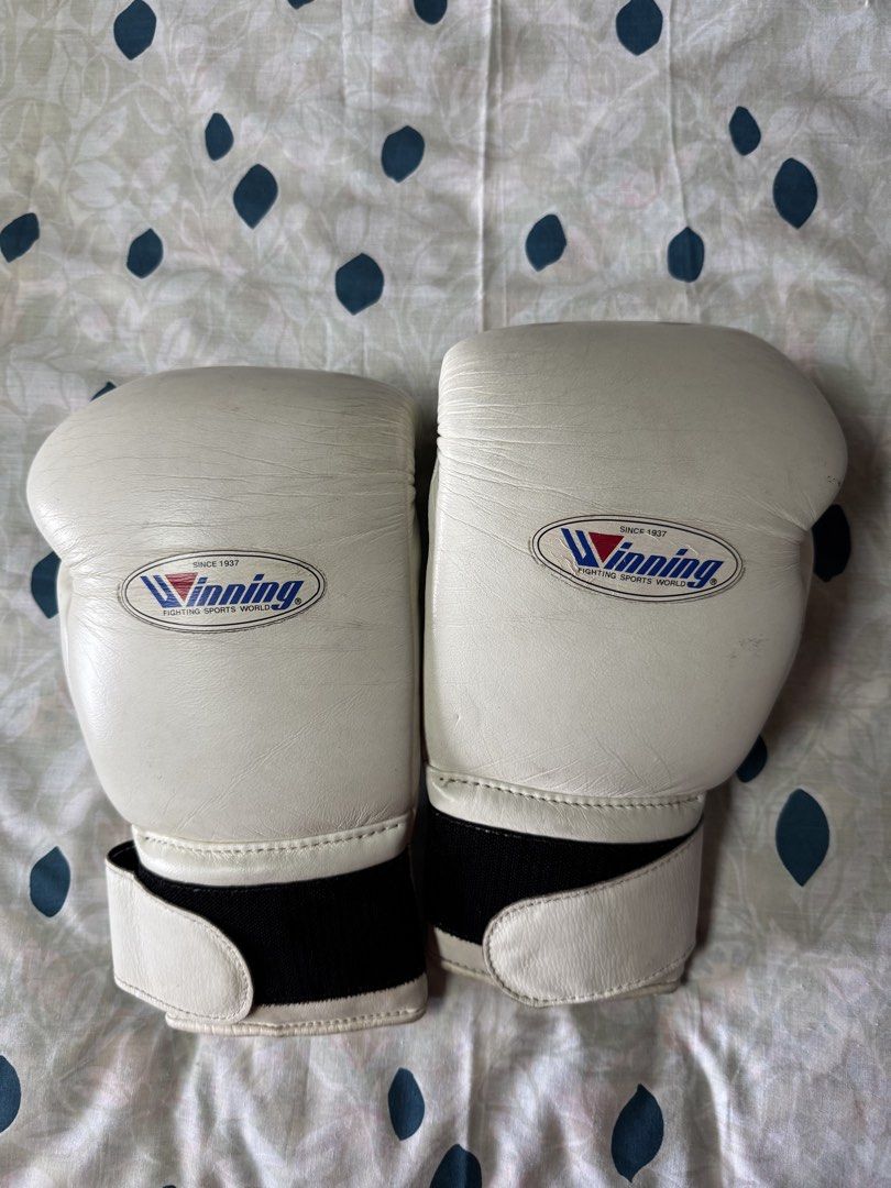Winning 16 oz White Training Boxing Gloves (Category: Combat Sports) located in Manila. Submitted by seangoart (Listing ID 1468350489, Image 1). Description: - Authentic Winning boxing gloves in clean white - 16 oz weight size stamped clearly on the back - Secure Velcro strap closure with black elastic stretch - Iconic Winning logo patch stitched on the front knuckle area - Minor natural creases on leather from normal training use - Palm ventilat