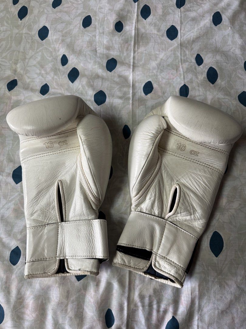 Winning 16 oz White Training Boxing Gloves (Category: Combat Sports) located in Manila. Submitted by seangoart (Listing ID 1468350489, Image 2). Description: - Authentic Winning boxing gloves in clean white - 16 oz weight size stamped clearly on the back - Secure Velcro strap closure with black elastic stretch - Iconic Winning logo patch stitched on the front knuckle area - Minor natural creases on leather from normal training use - Palm ventilat