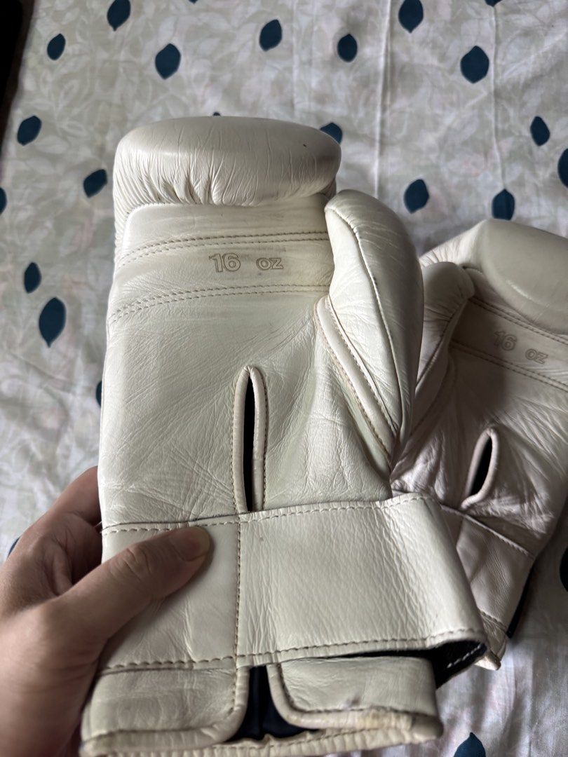 Winning 16 oz White Training Boxing Gloves (Category: Combat Sports) located in Manila. Submitted by seangoart (Listing ID 1468350489, Image 3). Description: - Authentic Winning boxing gloves in clean white - 16 oz weight size stamped clearly on the back - Secure Velcro strap closure with black elastic stretch - Iconic Winning logo patch stitched on the front knuckle area - Minor natural creases on leather from normal training use - Palm ventilat