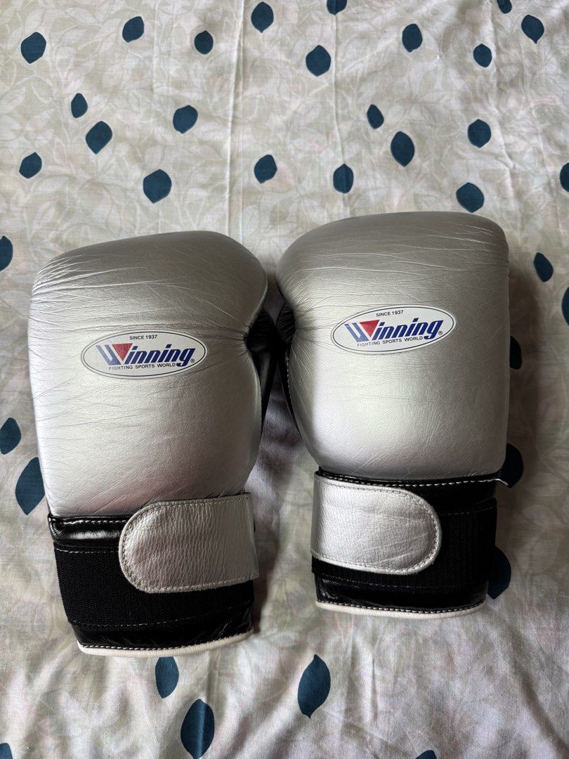 Winning Boxing Gloves 16 oz Silver and Black (Category: Combat Sports) located in Manila. Submitted by seangoart (Listing ID 1468350809, Image 1). Description: - Brand: Winning - Size: 16 oz - Color: Black and silver - Closure: Secure hook and loop - Material: Premium leather - Features: Solid wrist support, superior padding, and iconic wrist logo patch - Best for: Sparring and heavy bag workouts.