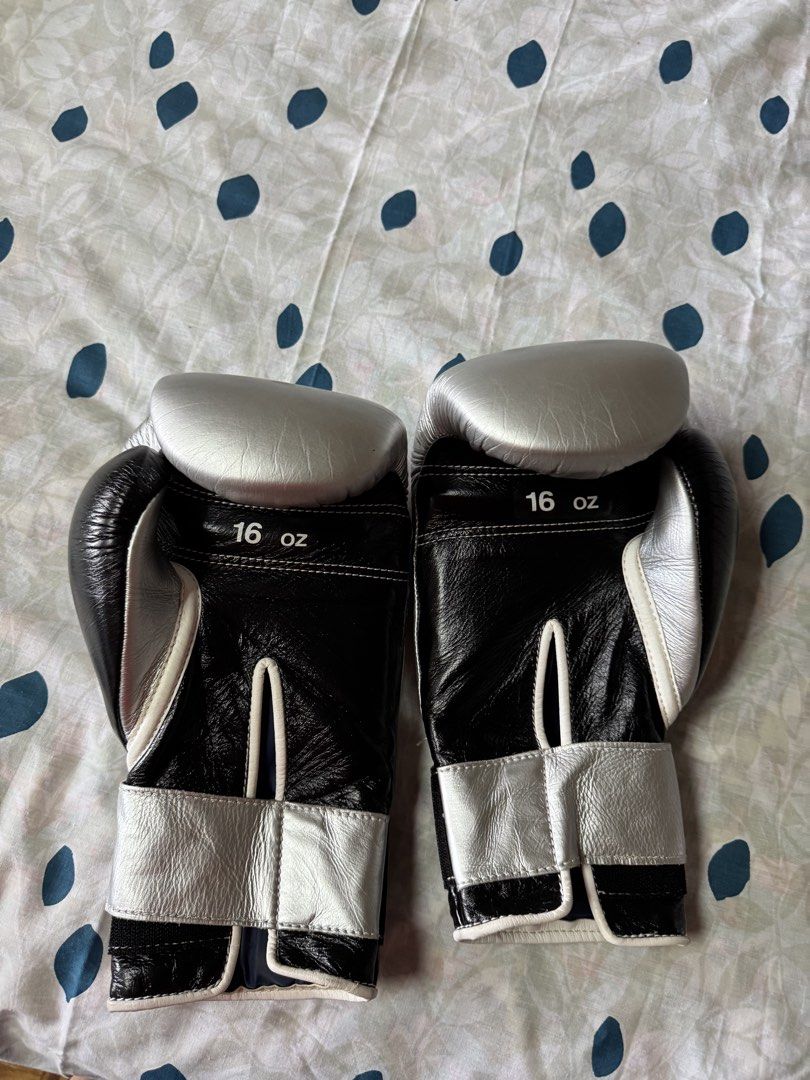 Winning Boxing Gloves 16 oz Silver and Black (Category: Combat Sports) located in Manila. Submitted by seangoart (Listing ID 1468350809, Image 2). Description: - Brand: Winning - Size: 16 oz - Color: Black and silver - Closure: Secure hook and loop - Material: Premium leather - Features: Solid wrist support, superior padding, and iconic wrist logo patch - Best for: Sparring and heavy bag workouts.