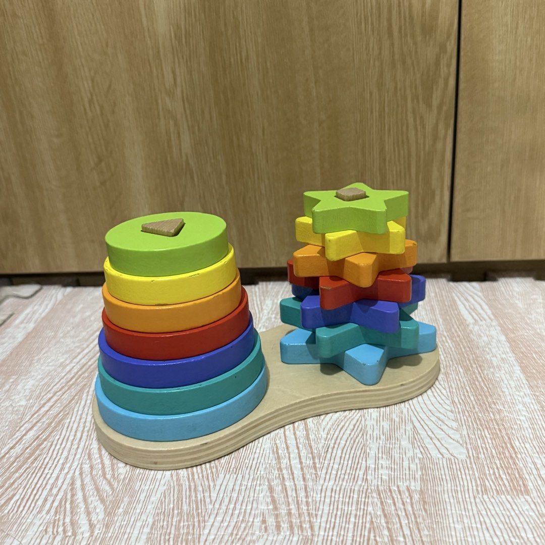 Wooden rainbow shape stacking toy for toddlers (Category: Educational & Learning Toys) located in Marikina City. Submitted by lovegoeson (Listing ID 1468310215, Image 2). Description: - 2-in-1 wooden stacking toy with dual vertical pegs and a sturdy base - Features colourful round rings on one side and matching star shapes on the other - Rainbow colour assortment includes lime green, yellow, orange, red, purple, turquoise, and blue - Excellent to