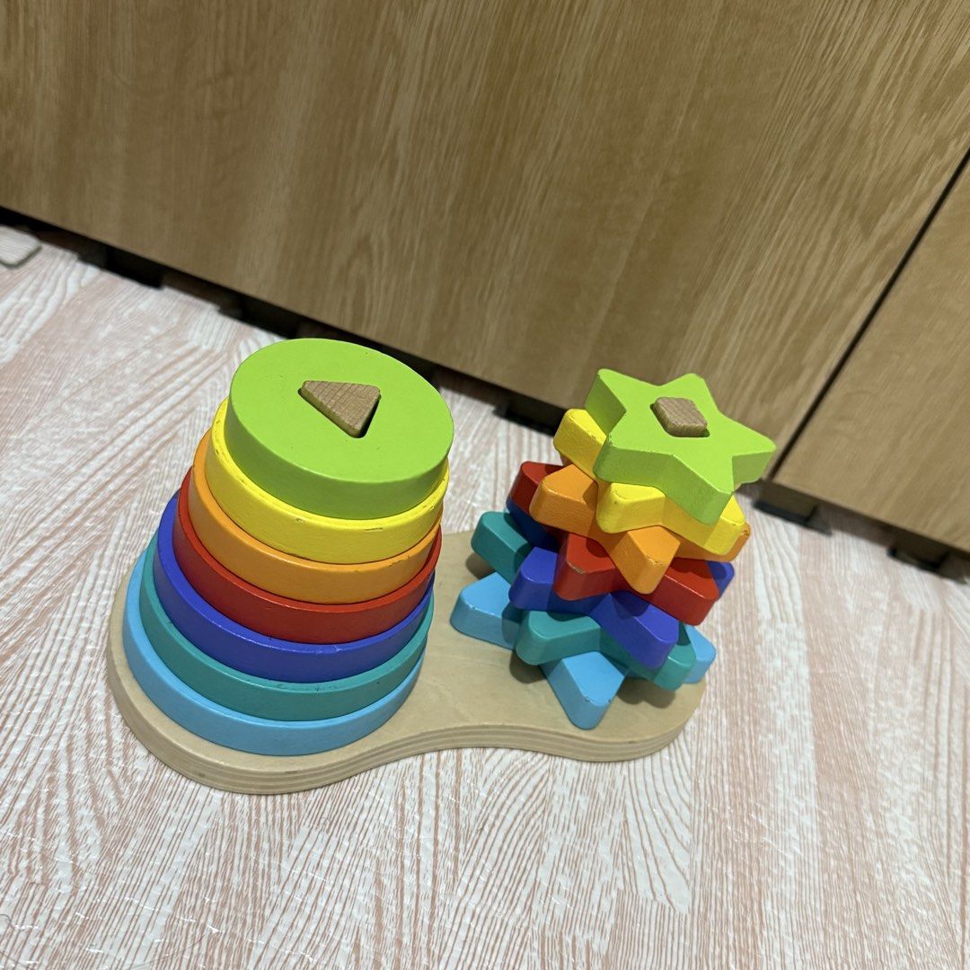 Wooden rainbow shape stacking toy for toddlers (Category: Educational & Learning Toys) located in Marikina City. Submitted by lovegoeson (Listing ID 1468310215, Image 3). Description: - 2-in-1 wooden stacking toy with dual vertical pegs and a sturdy base - Features colourful round rings on one side and matching star shapes on the other - Rainbow colour assortment includes lime green, yellow, orange, red, purple, turquoise, and blue - Excellent to