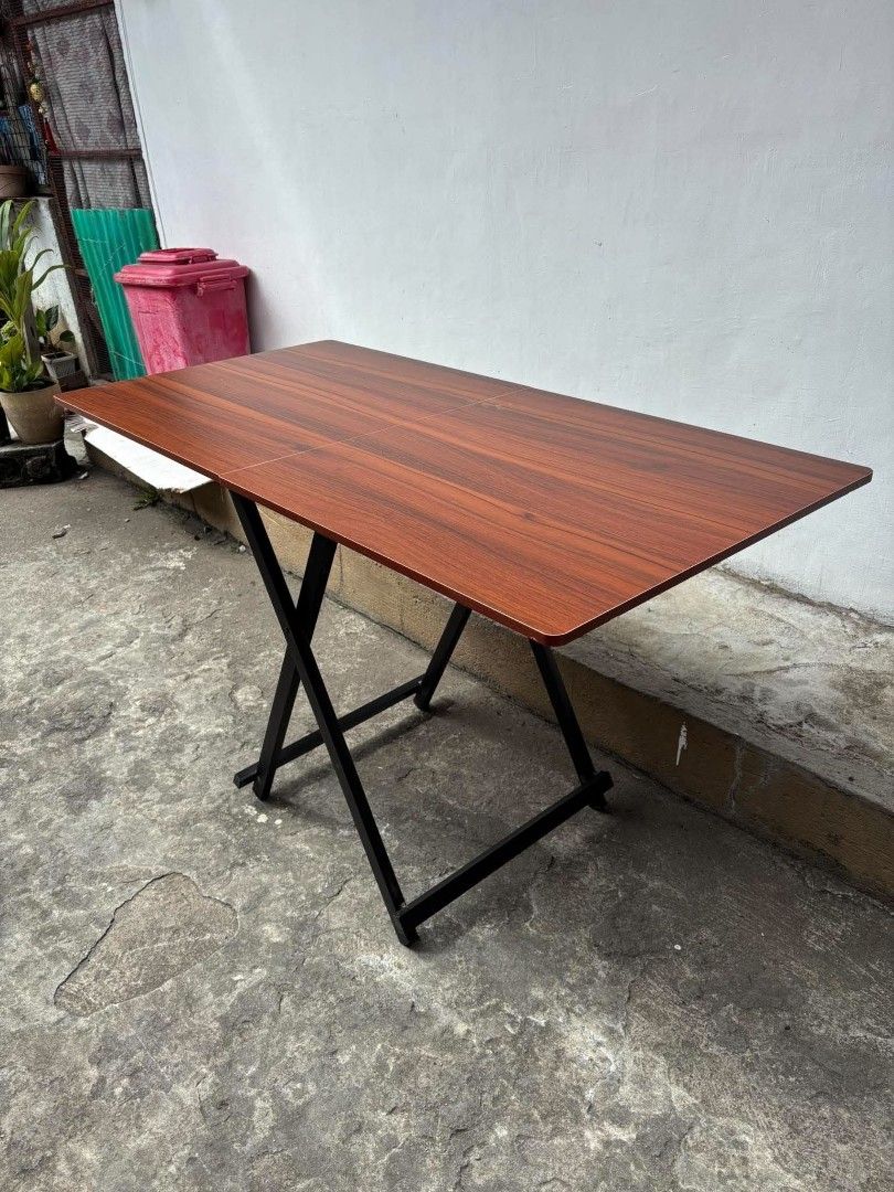 Wooden Top Folding Dining Table with Metal Scissors Frame (Category: Tables & Sets) located in Manila. Submitted by ajimdolor012051 (Listing ID 1468325916, Image 2). Description: - Rectangular wooden top with a rich brown grain finish - Sturdy black metal base with a folding scissor mechanism - Folds flat completely for effortless storage - Excellent space-saver ideal for compact apartments or multi-use rooms - 120cm ang haba.