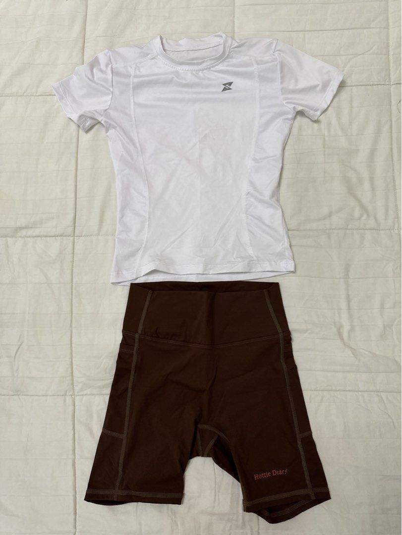 Workout Set (Category: Activewear) located in Quezon City. Submitted by m3gan8 (Listing ID 1468380386, Image 1). Description: - 2-piece activewear set (sold together) - White short-sleeve athletic top with a subtle logo on the chest - High-waisted brown biker shorts with convenient side pockets - Cute 'Hottie Diary' print near the short hem - Stretchy, comfortable fabric ideal for gym workouts, running, or casual wear.
