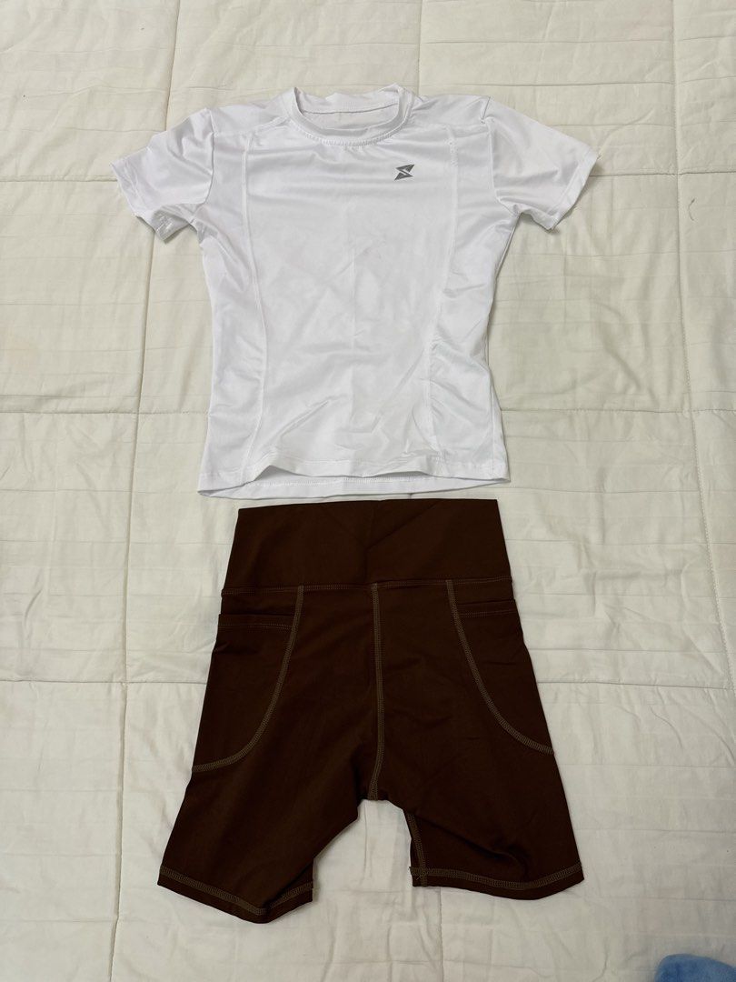 Workout Set (Category: Activewear) located in Quezon City. Submitted by m3gan8 (Listing ID 1468380386, Image 3). Description: - 2-piece activewear set (sold together) - White short-sleeve athletic top with a subtle logo on the chest - High-waisted brown biker shorts with convenient side pockets - Cute 'Hottie Diary' print near the short hem - Stretchy, comfortable fabric ideal for gym workouts, running, or casual wear.