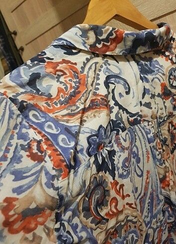 Zara Basic Paisley Print Button-Up Blouse (Category: Blouses) located in Lupao. Submitted by selahthriftedclothing (Listing ID 1468375550, Image 3). Description: - Brand: Zara Basic - Design: White with blue and orange paisley pattern all over - Neckline: V-neck collar - Fabric: Lightweight and comfortable - Versatility: Perfect for casual daily wear or office styling - Pairing: Easy to match with denim or trousers - Siting: Standard sizing.